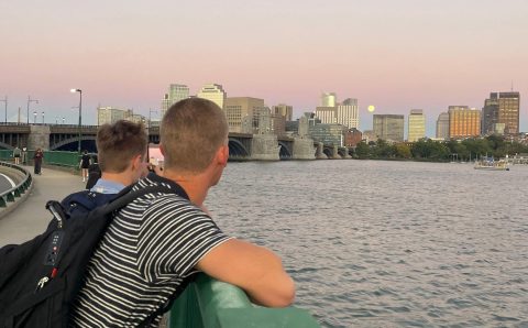two students overlooking charles river
