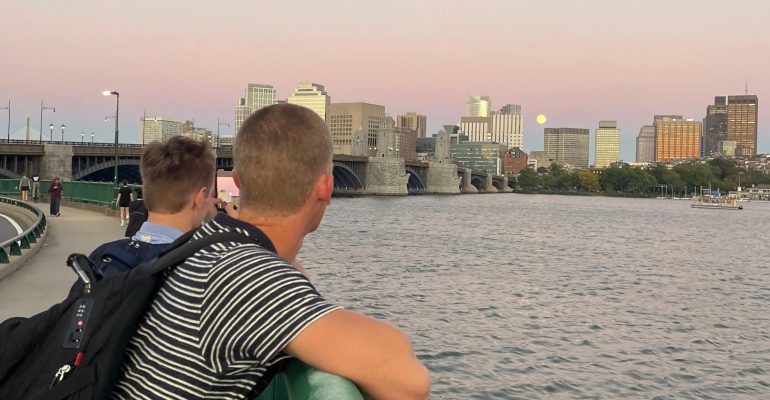 two students overlooking charles river